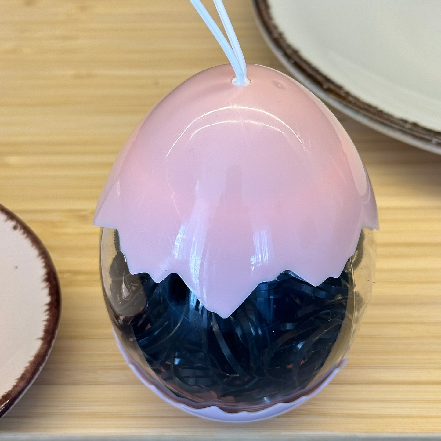 Juodos guminės gumytės rūžavame kiaušinio dėkle