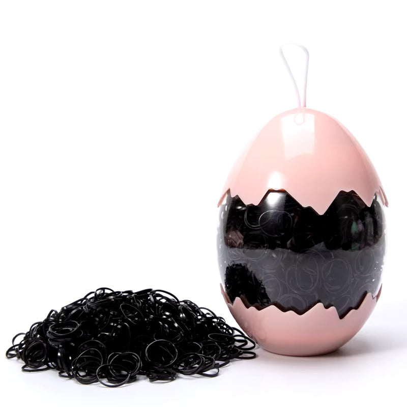 Juodos guminės gumytės rūžavame kiaušinio dėkle